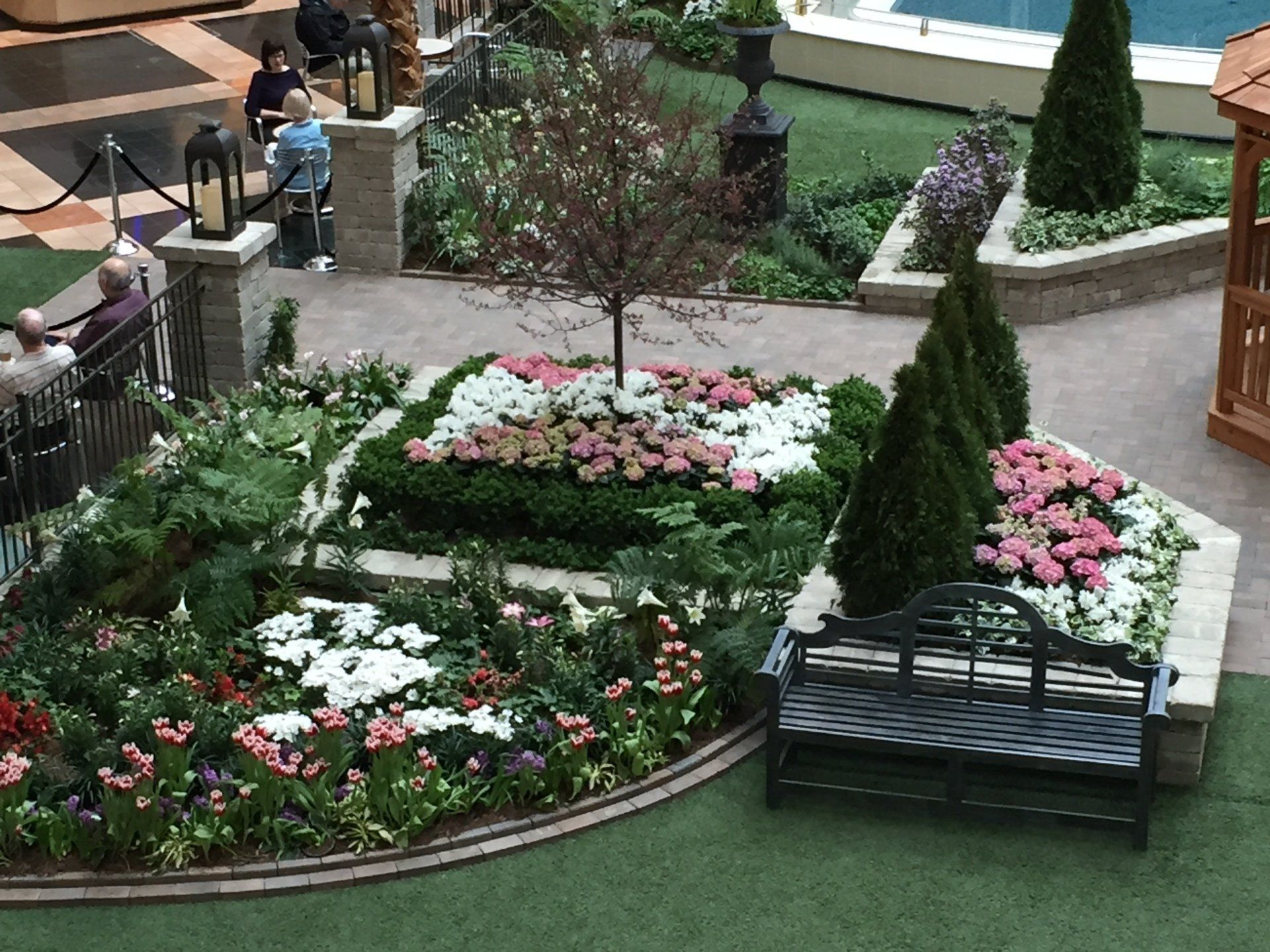 A garden with flowers and a bench in the middle