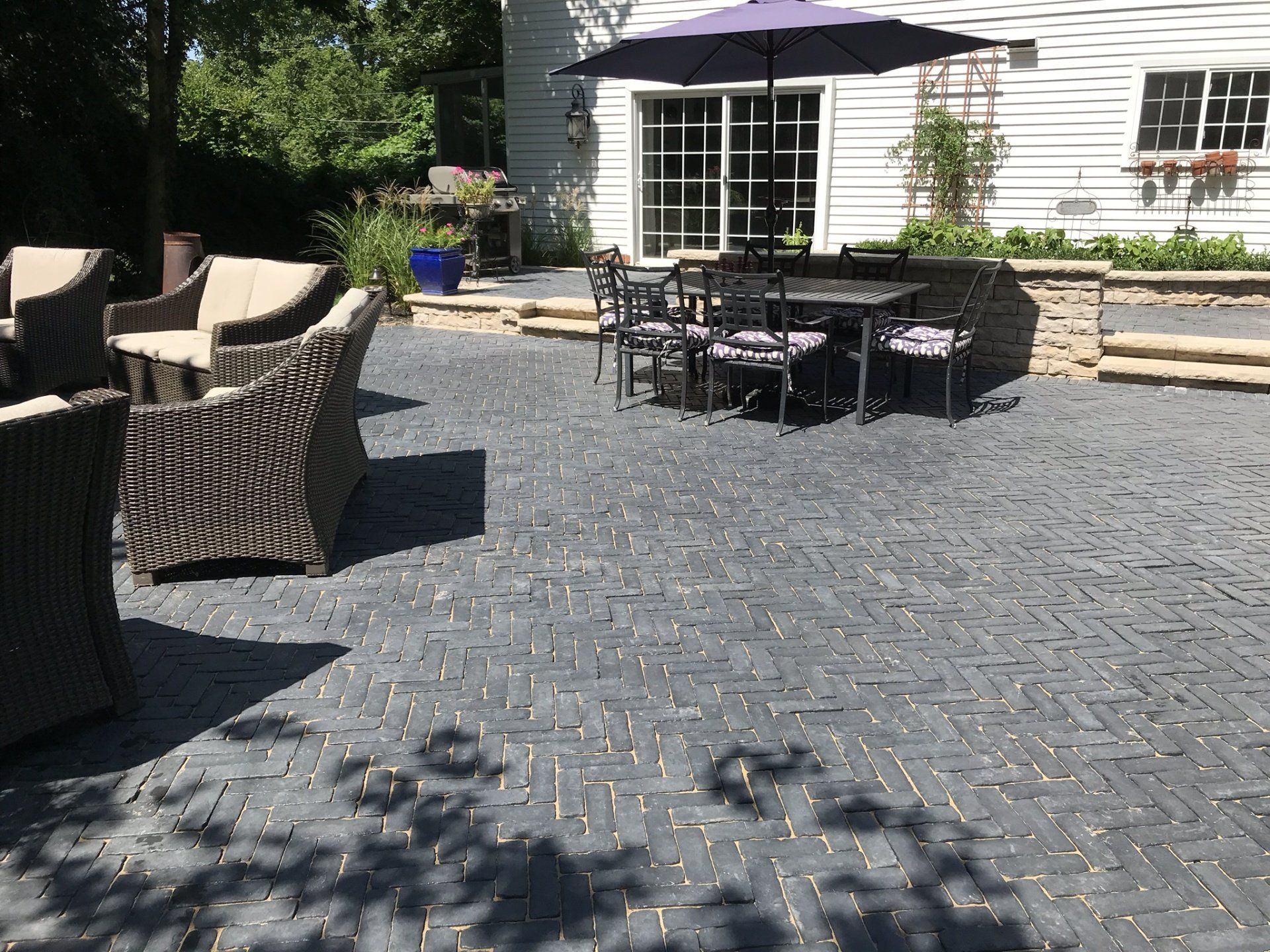 A patio with a table and chairs and a purple umbrella