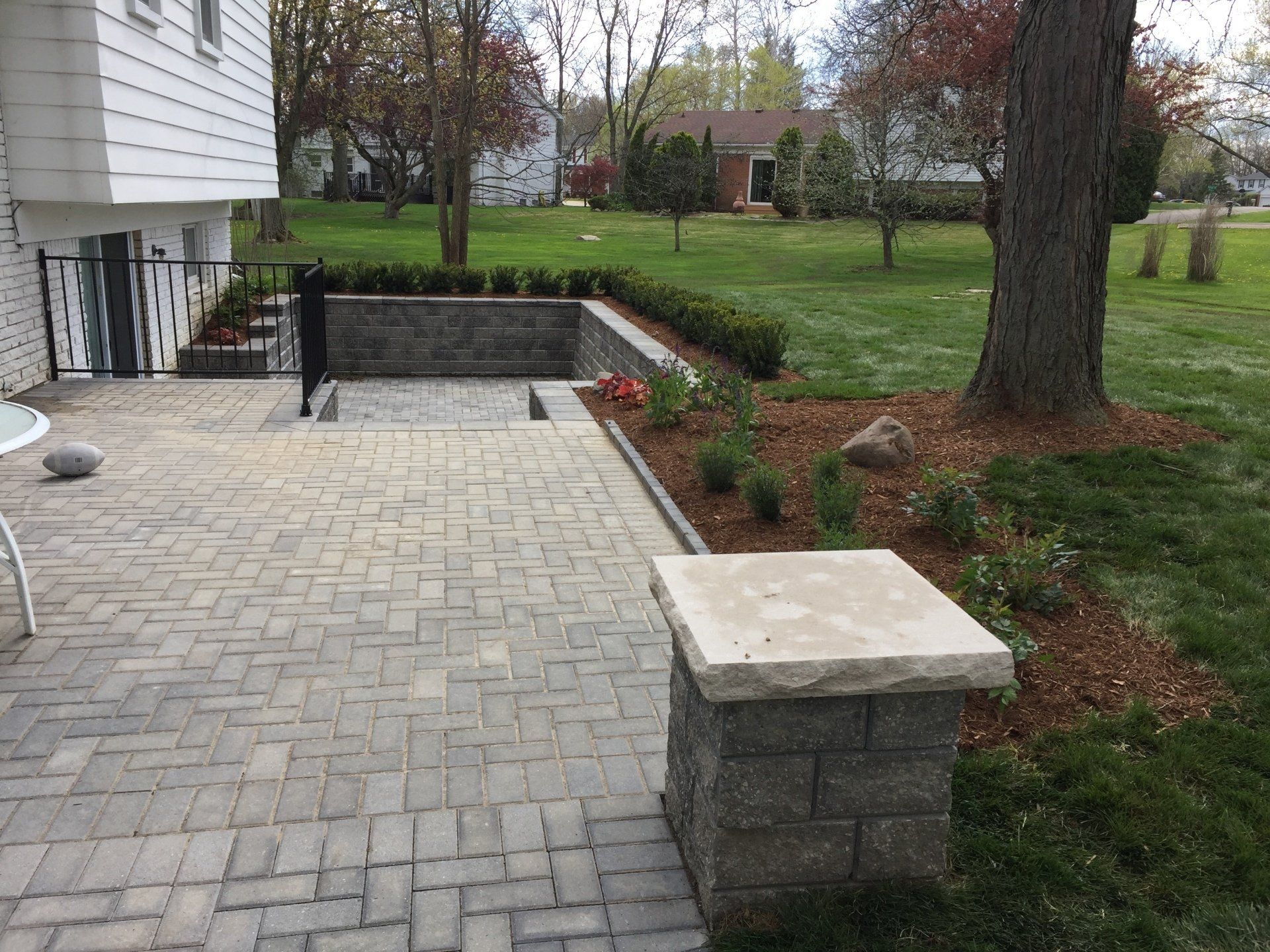 A patio with a brick walkway leading to a basement