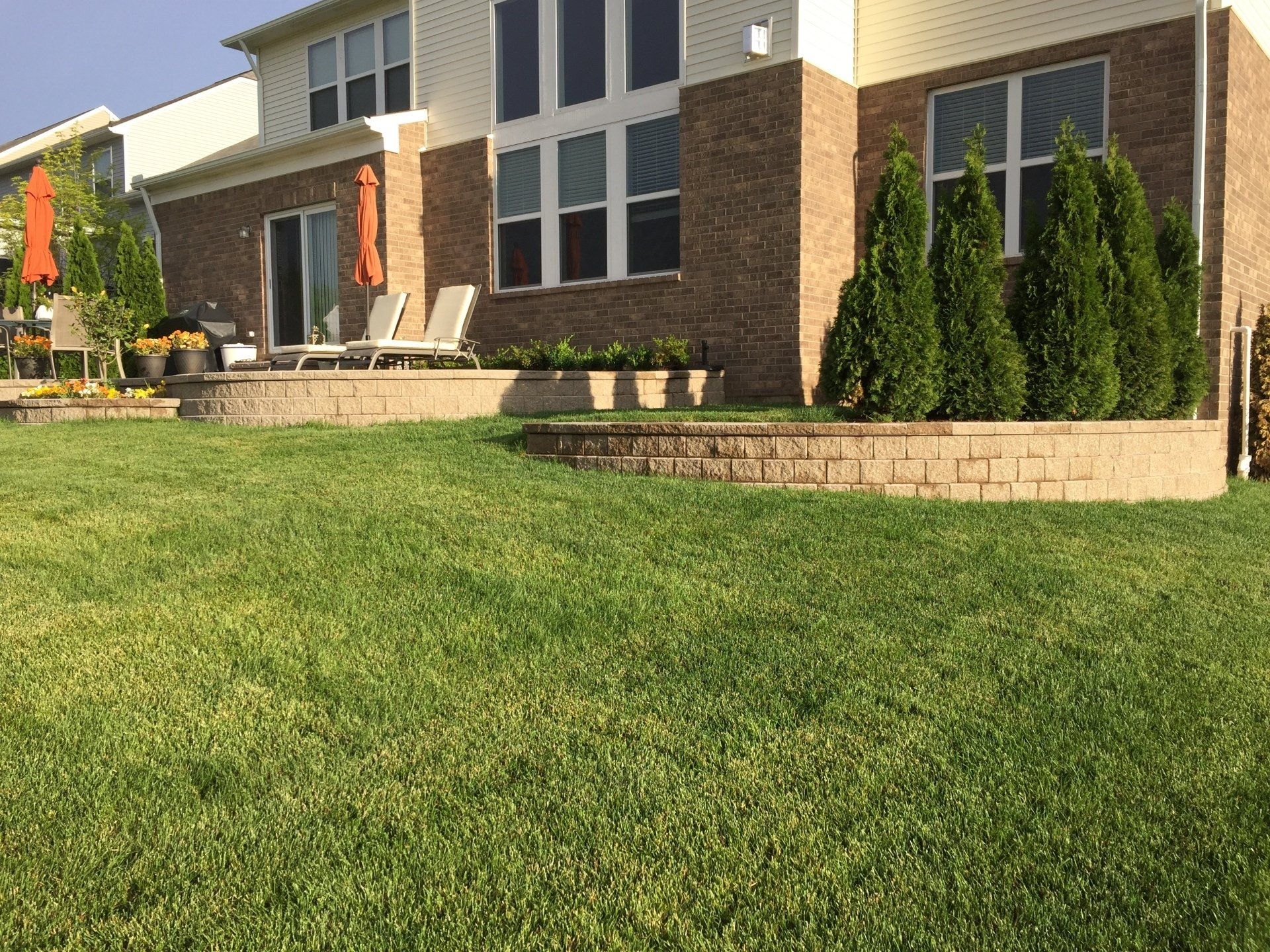 A large brick house with a lush green lawn in front of it.