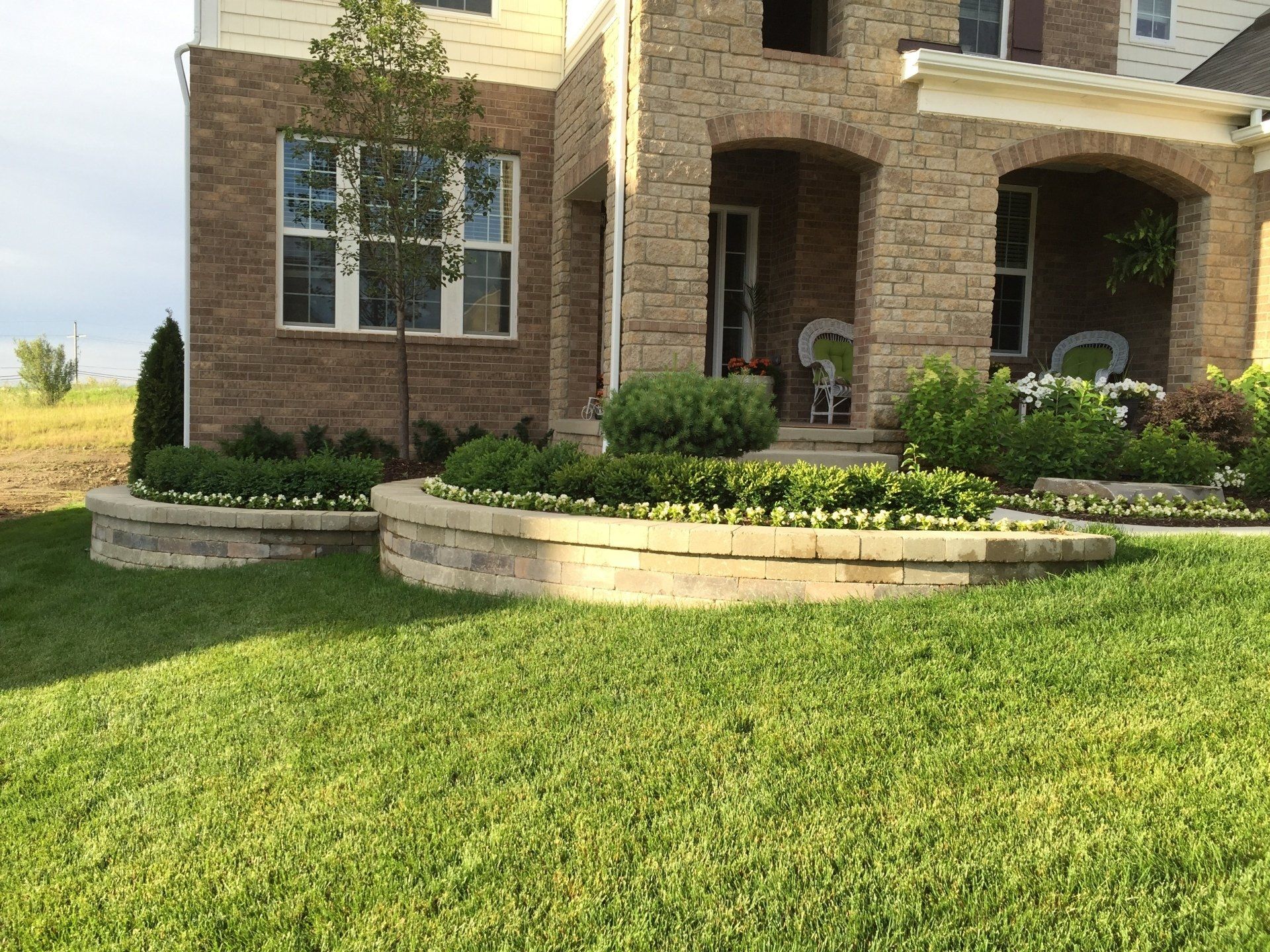 A large brick house with a lush green lawn in front of it
