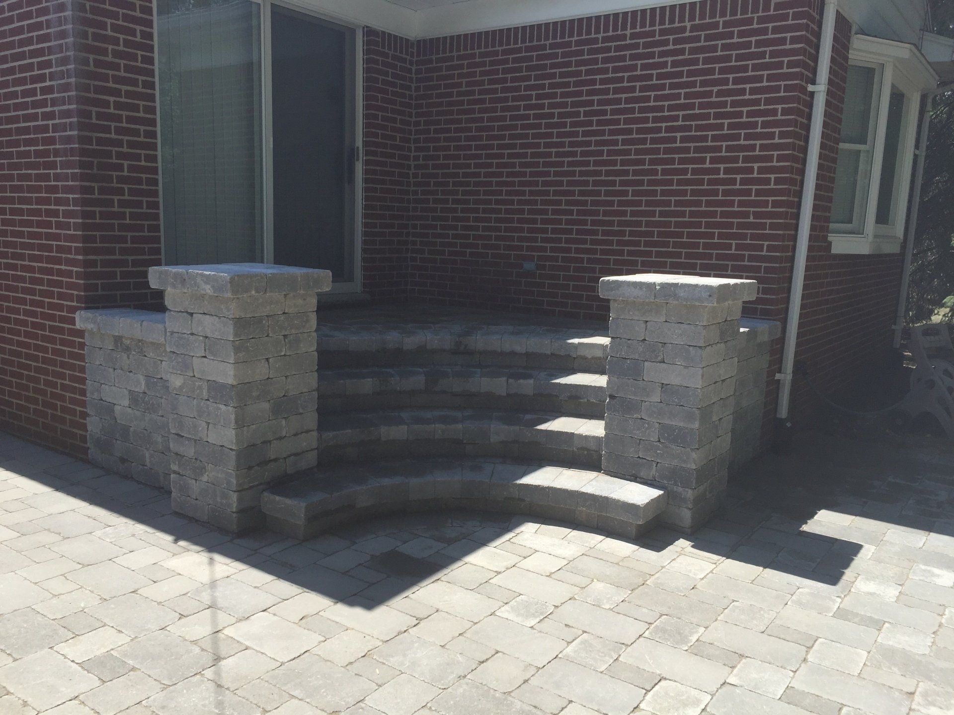 A brick house with stairs leading up to the front door.
