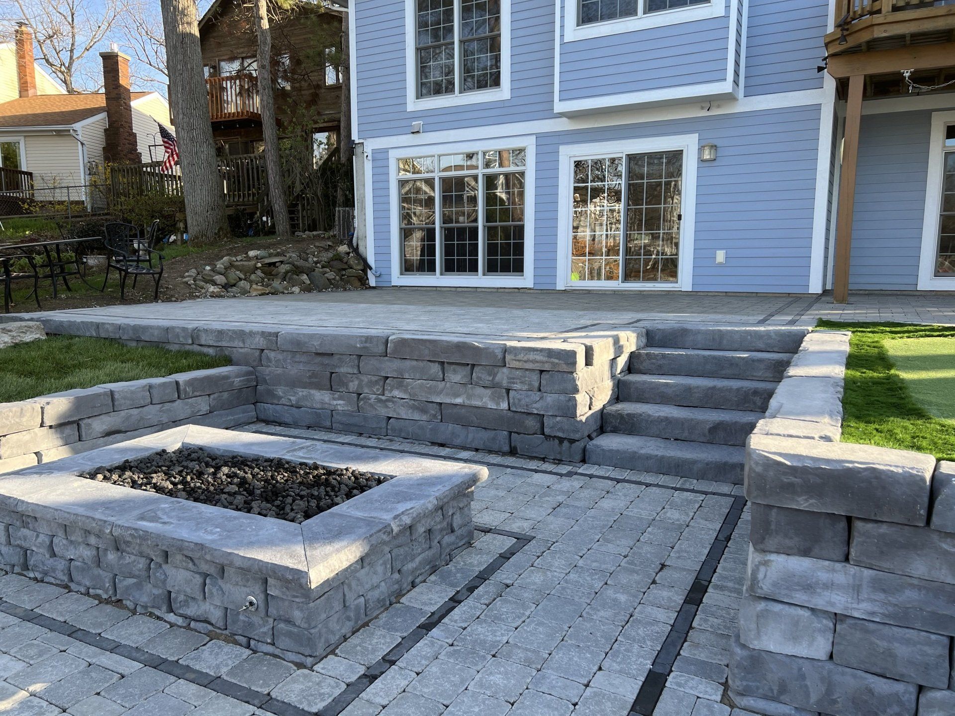 There is a fire pit in the backyard of a house.