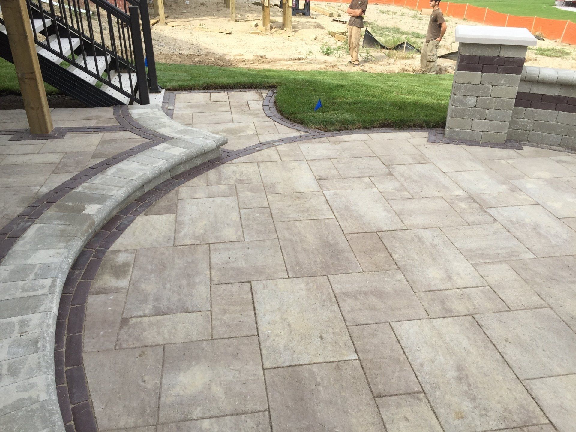 A patio with a staircase and a playground in the background
