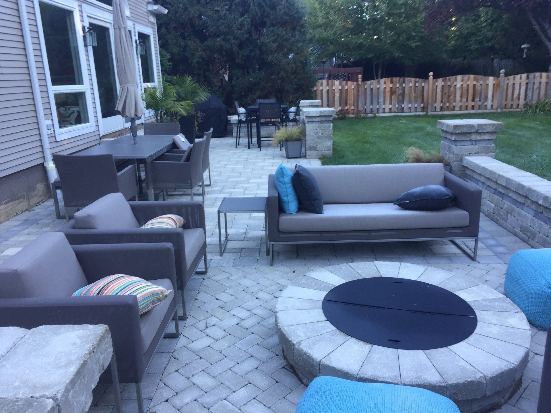 A patio with a couch and chairs and a fire pit