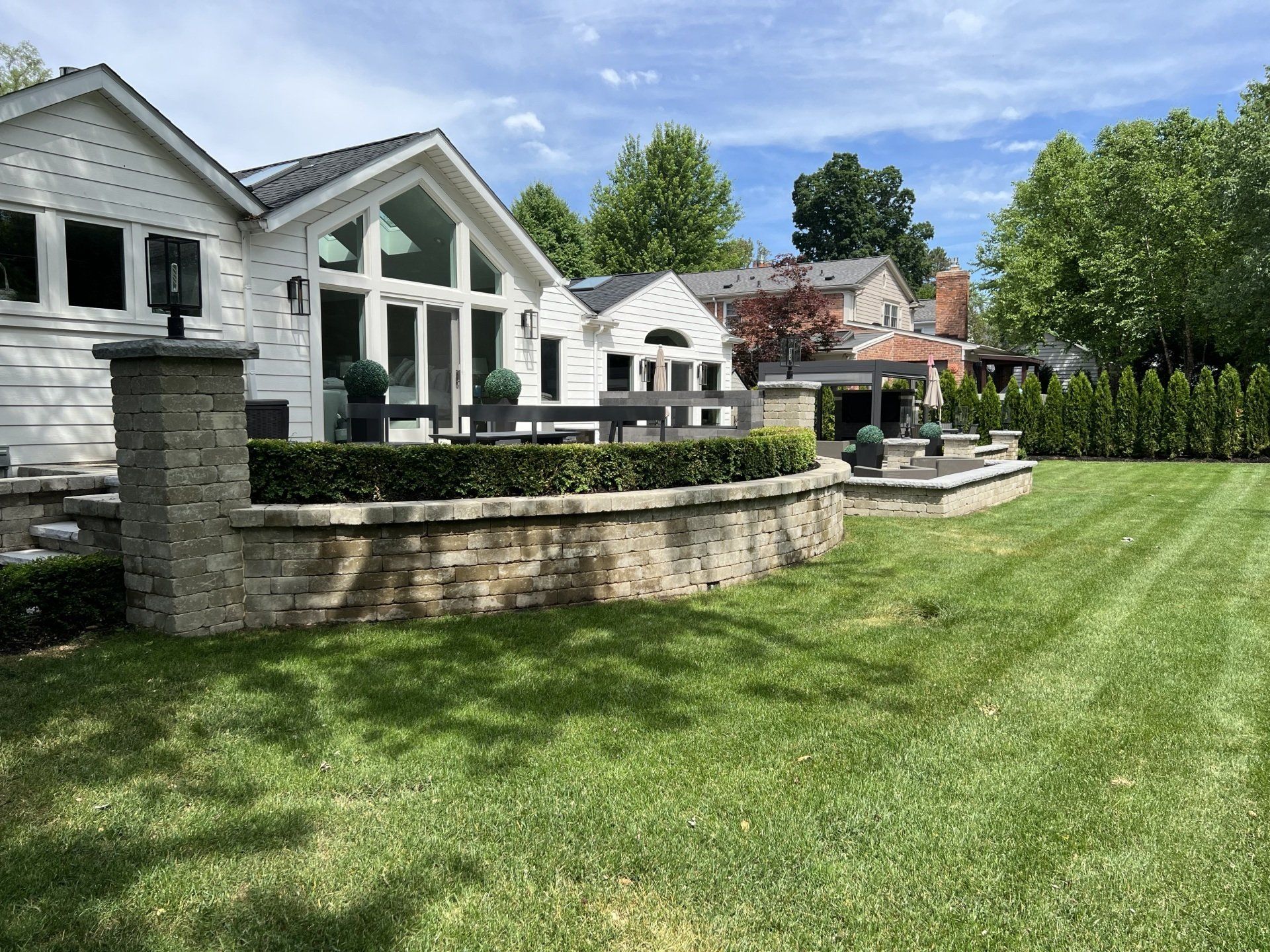 A white house with a large lawn in front of it.