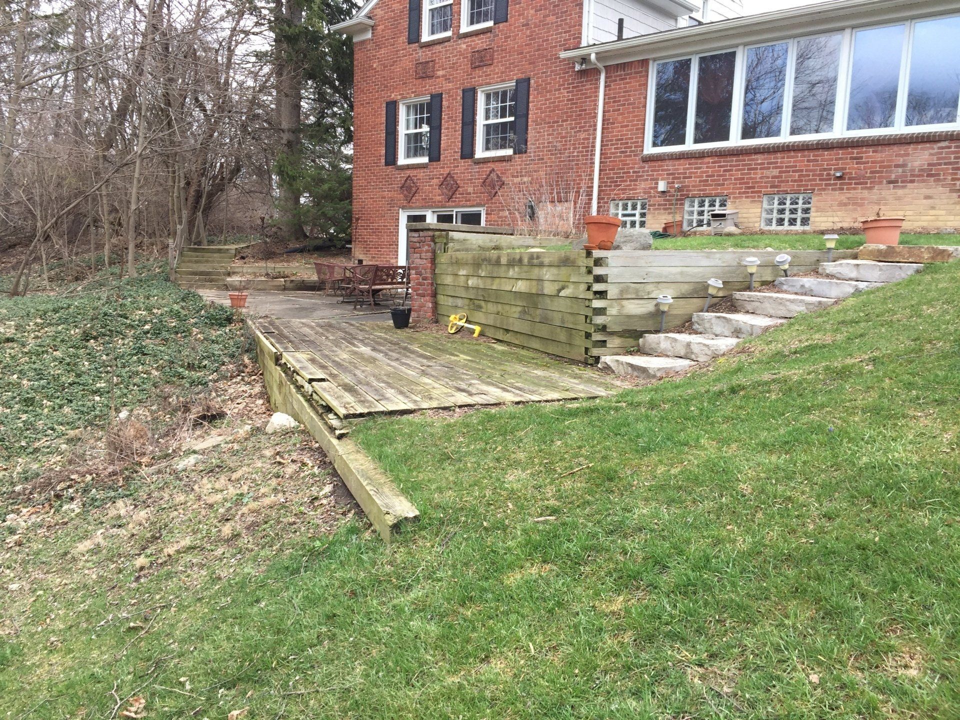 A brick house with a wooden deck in front of it.