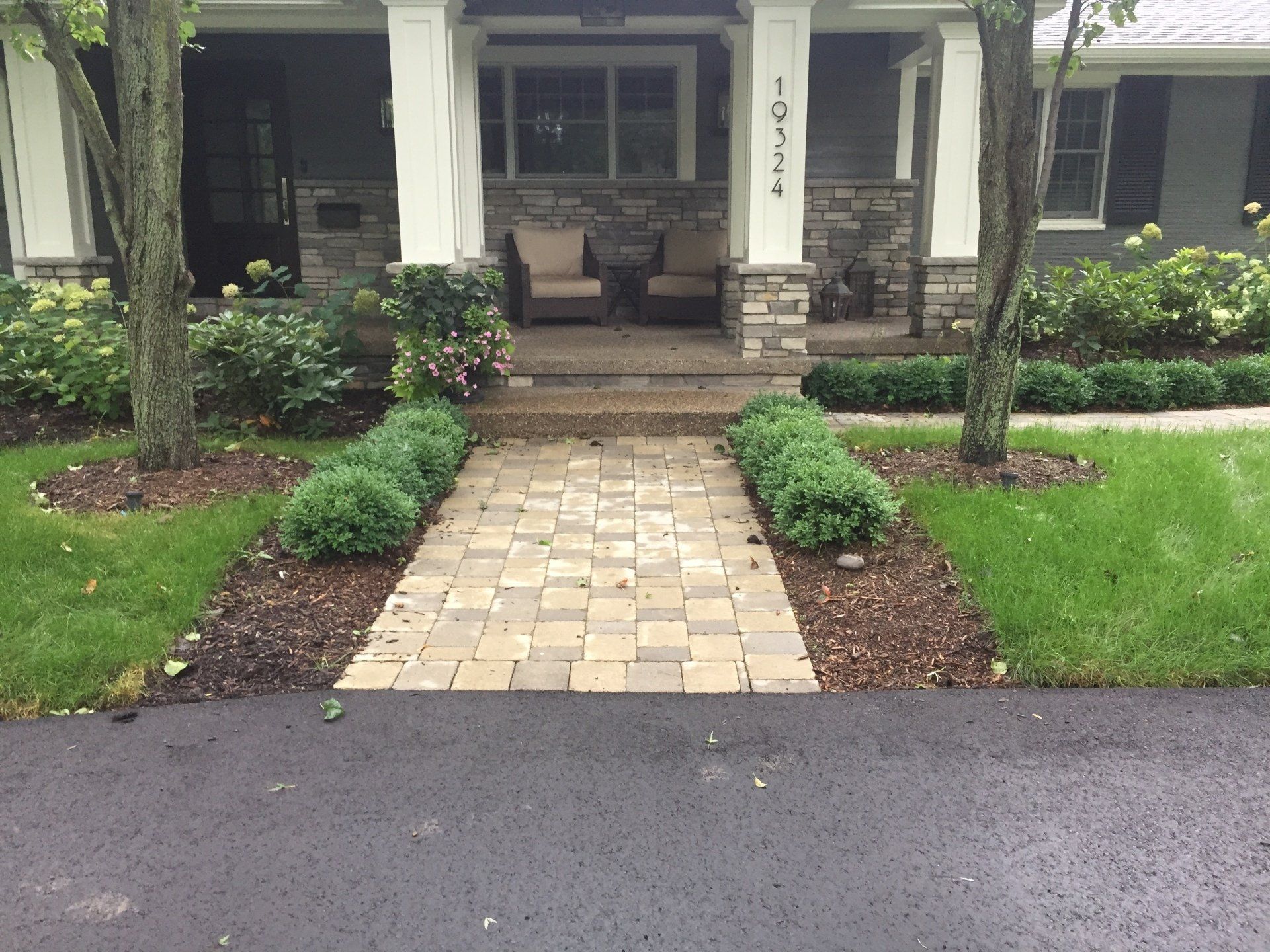 A brick walkway leading to the front of a house
