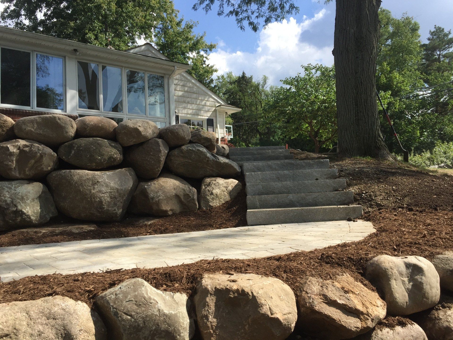 A stone wall with stairs leading up to a house