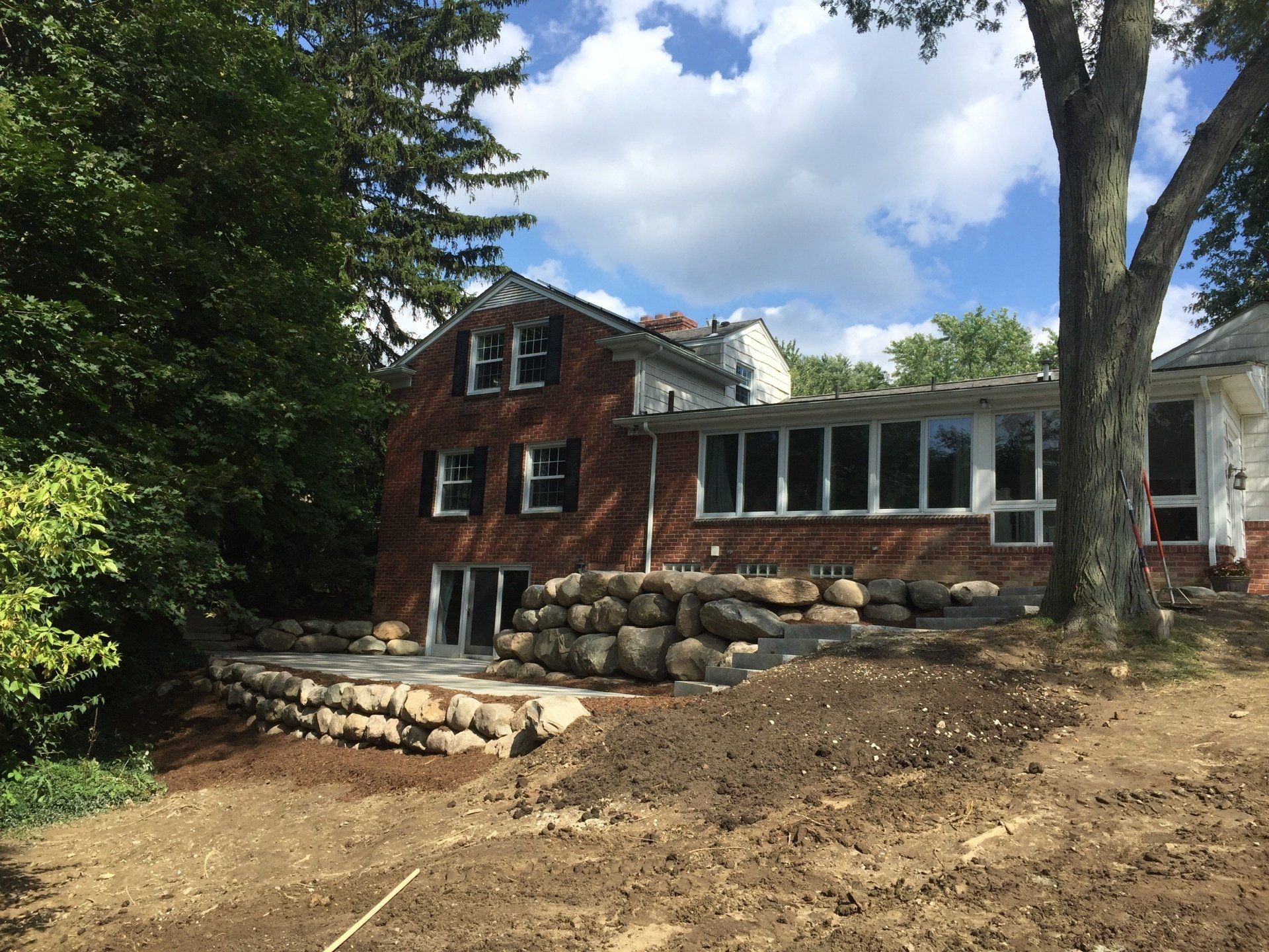 A large brick house with a tree in front of it