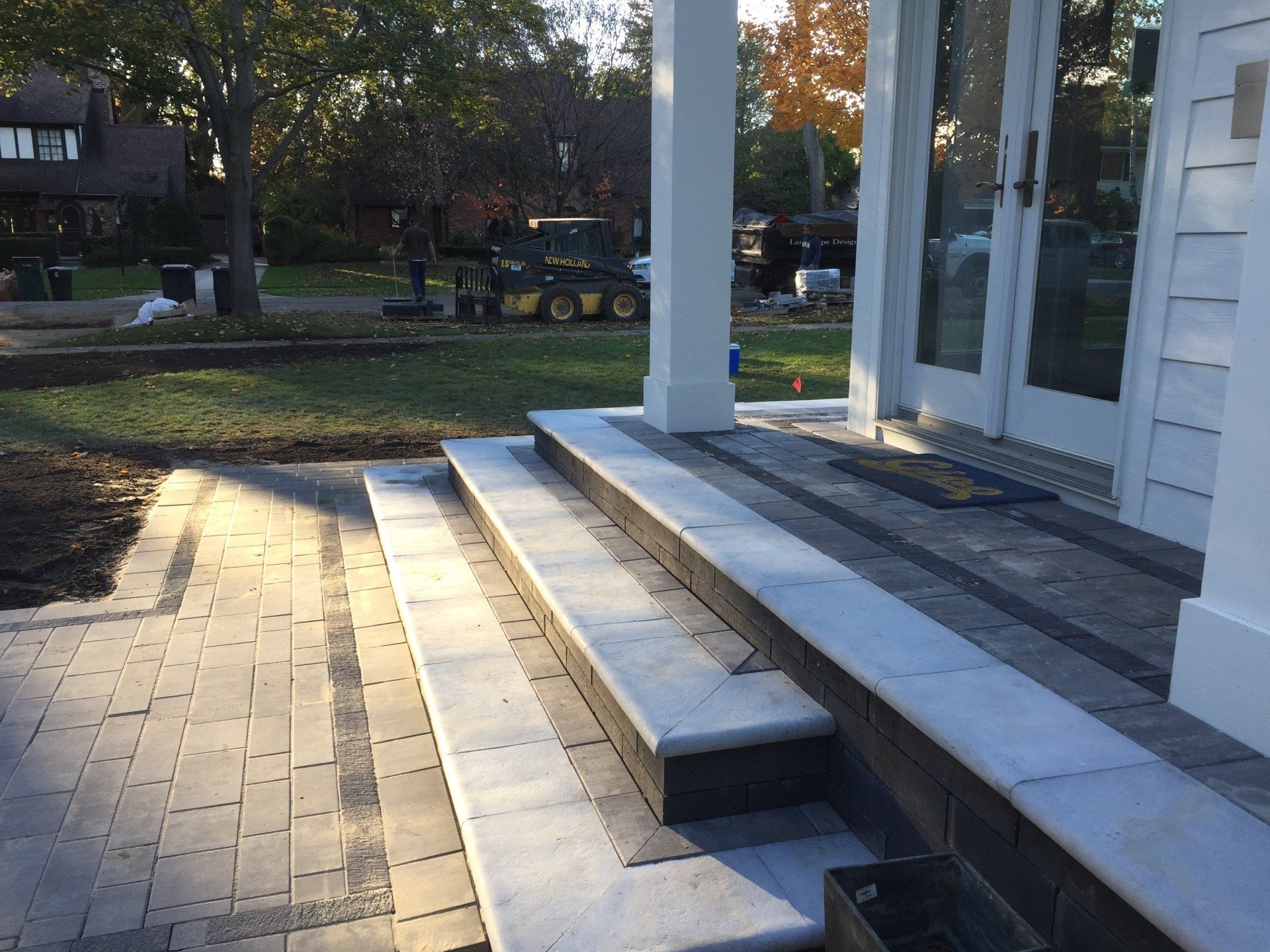 A set of stairs leading up to a porch with a white house in the background