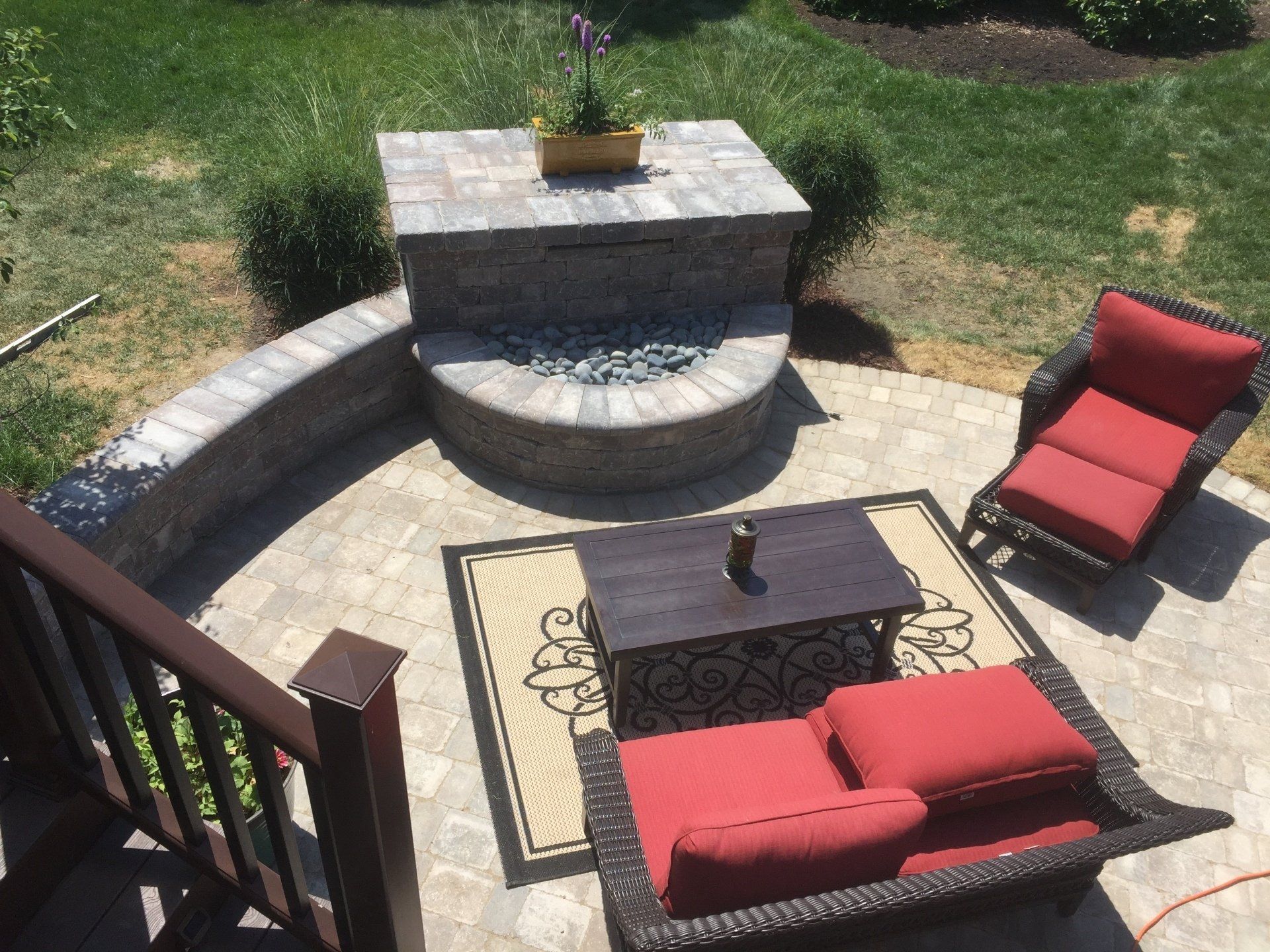 A patio with red chairs and a coffee table