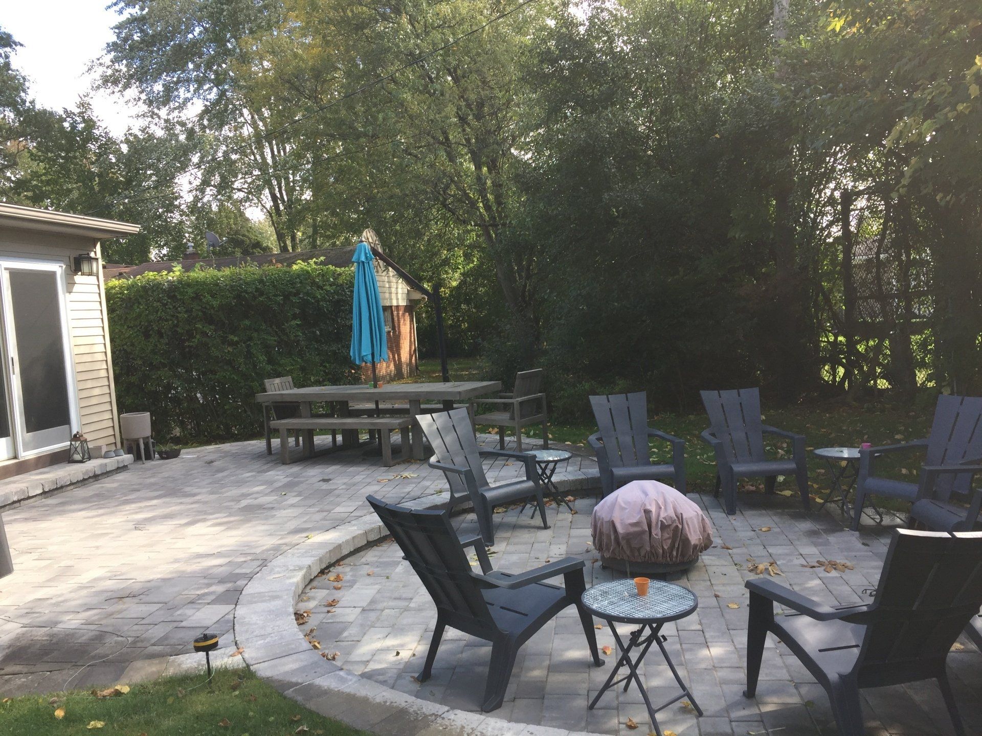 A patio with chairs , tables and an umbrella