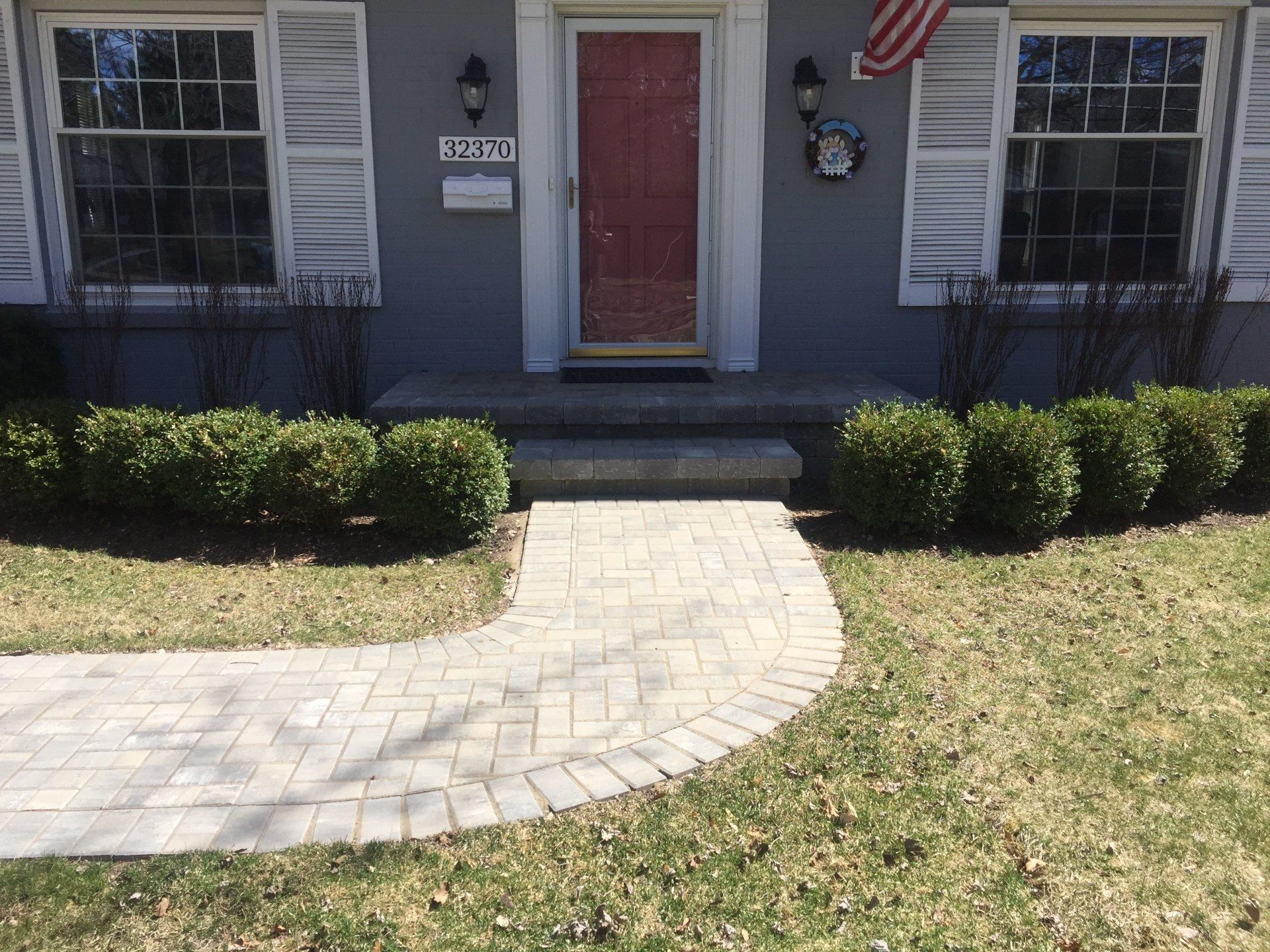 A brick walkway leading to the front door of a house