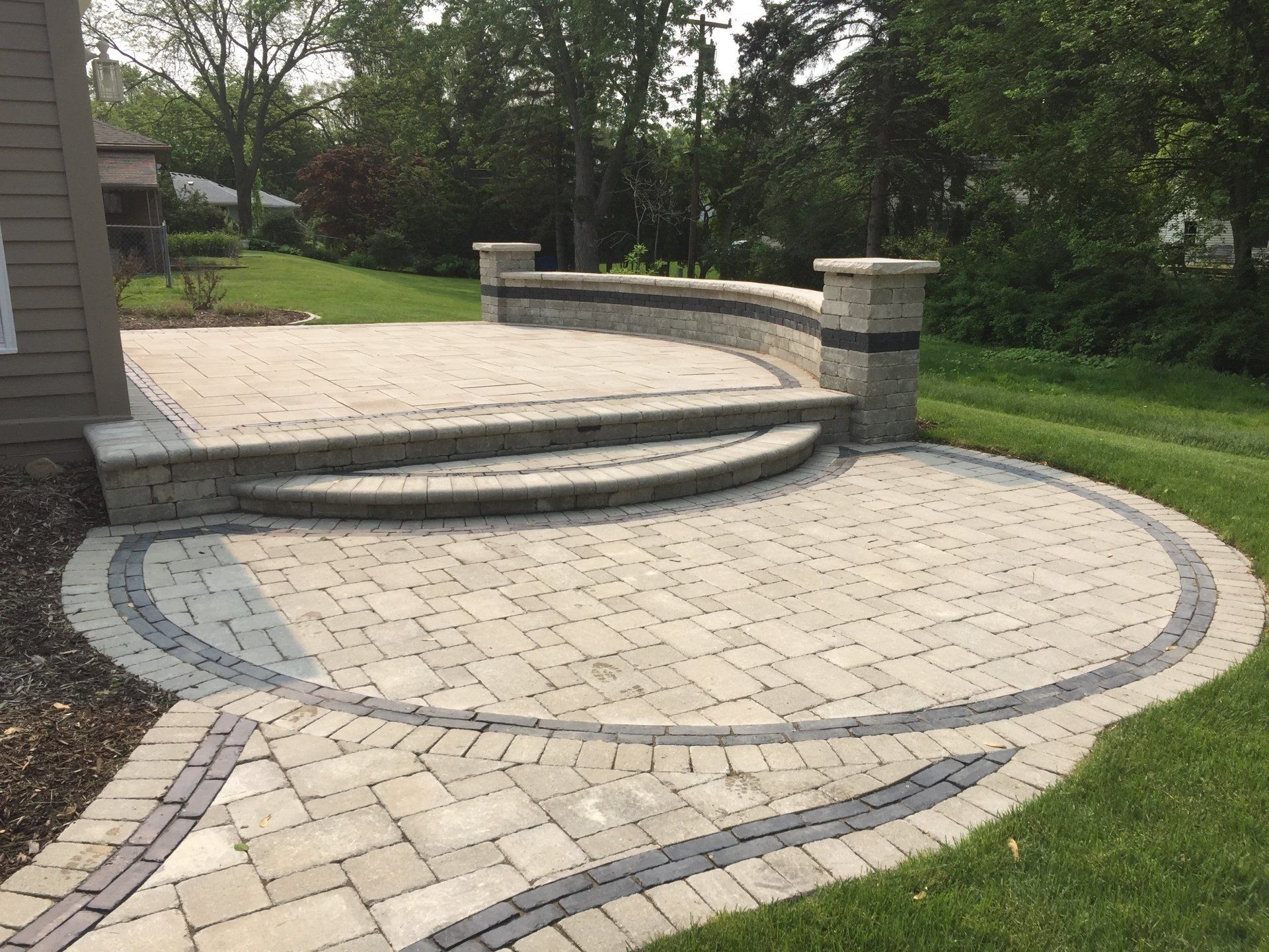 A patio with steps and a wall in the backyard