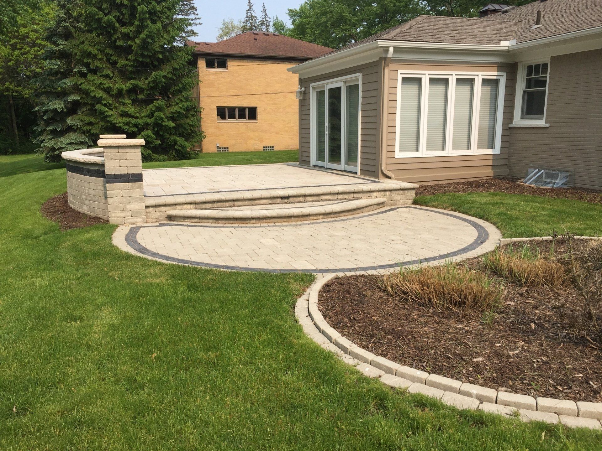 There is a patio in the backyard of a house.