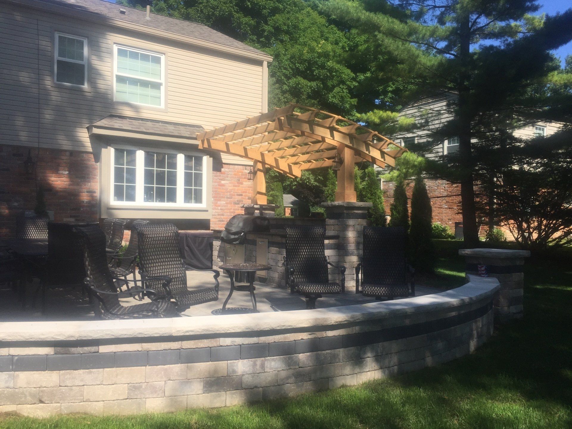 A house with a patio and a pergola in front of it.