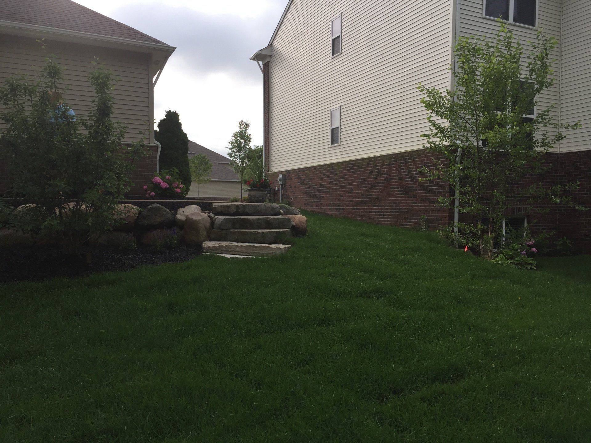 A house with stairs leading up to it and a lush green lawn