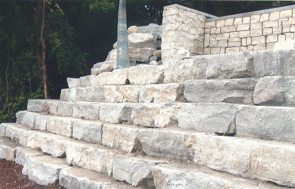 A set of stairs made of large rocks with trees in the background