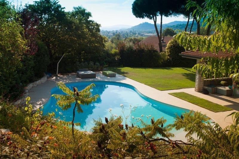 Piscina con giardino, lavorazioni in pietra per bordo e vialetti