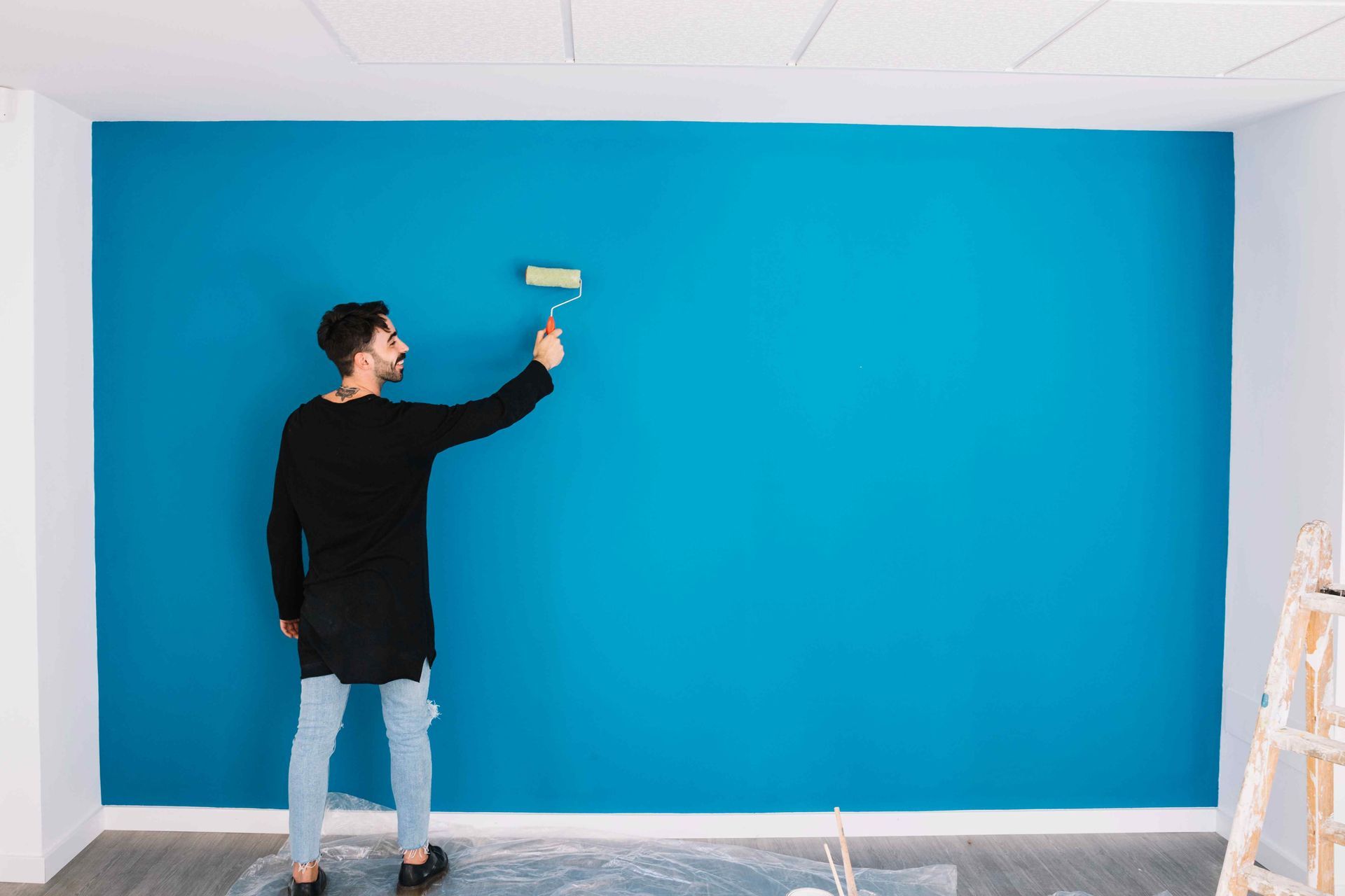 man painting wall blue