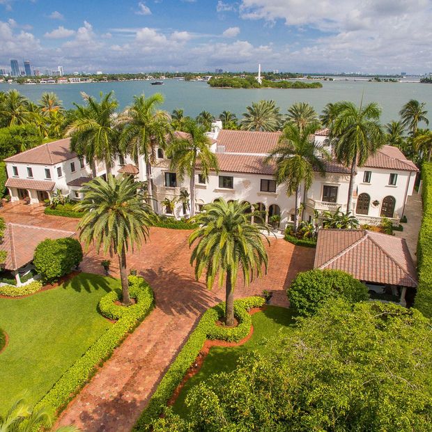 A large white house with a lush green lawn in front of it.