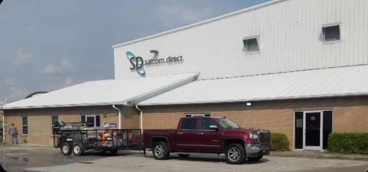 A red truck is parked in front of a building.