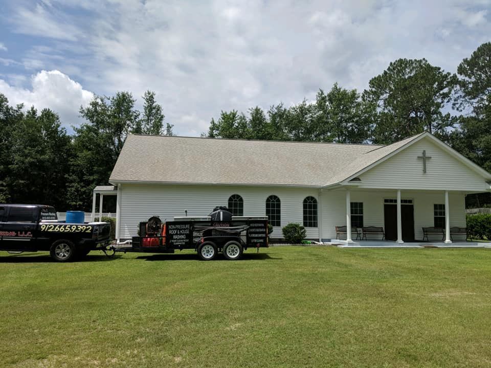 A truck is parked in front of a church with a cross on it