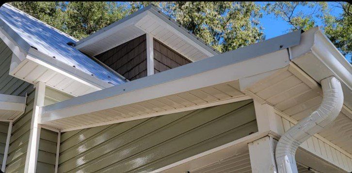 A house with a white gutter on the side of it.