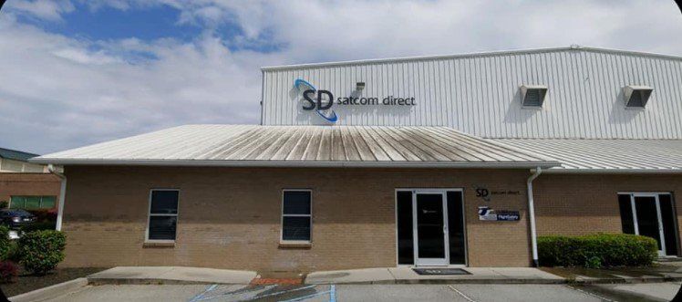 A large brick building with a white roof and a sign that says sd on it