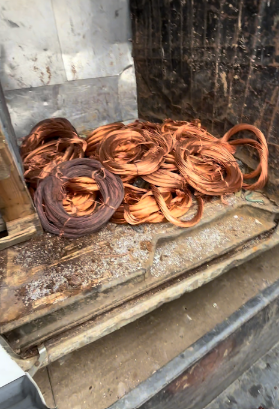 Ritagli di filo di rame in un contenitore metallico, di varie dimensioni e colori.