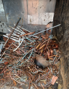 Tubi di rame e altri metalli di scarto in un bidone, di varie forme e colori.