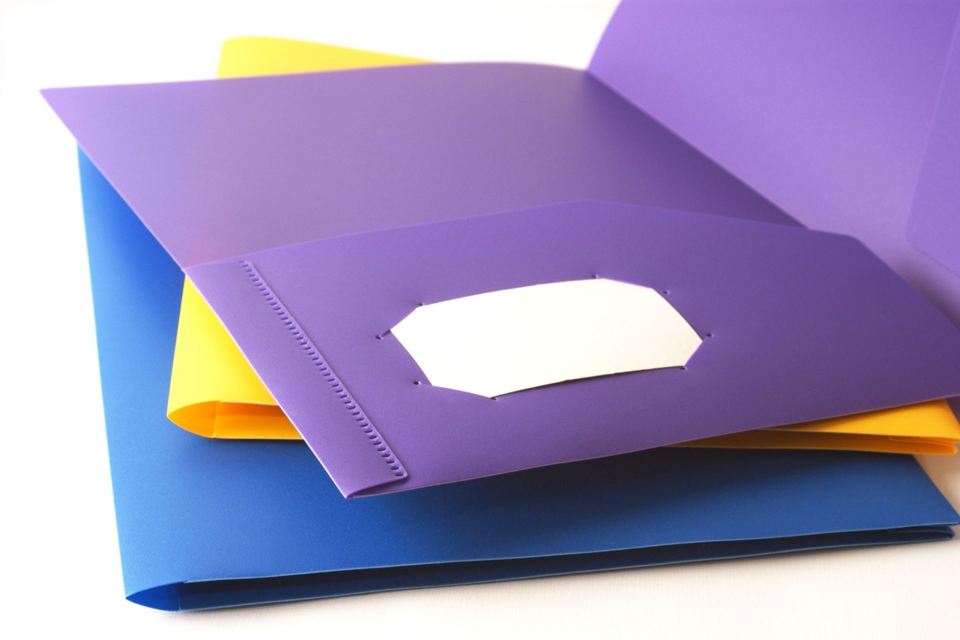 A purple folder is sitting on top of a blue folder