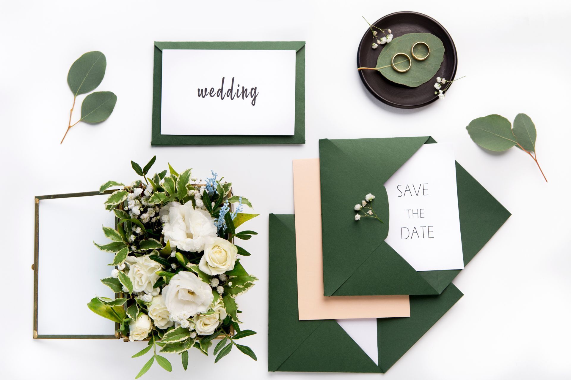 A wedding invitation and envelope with flowers and leaves on a white background.