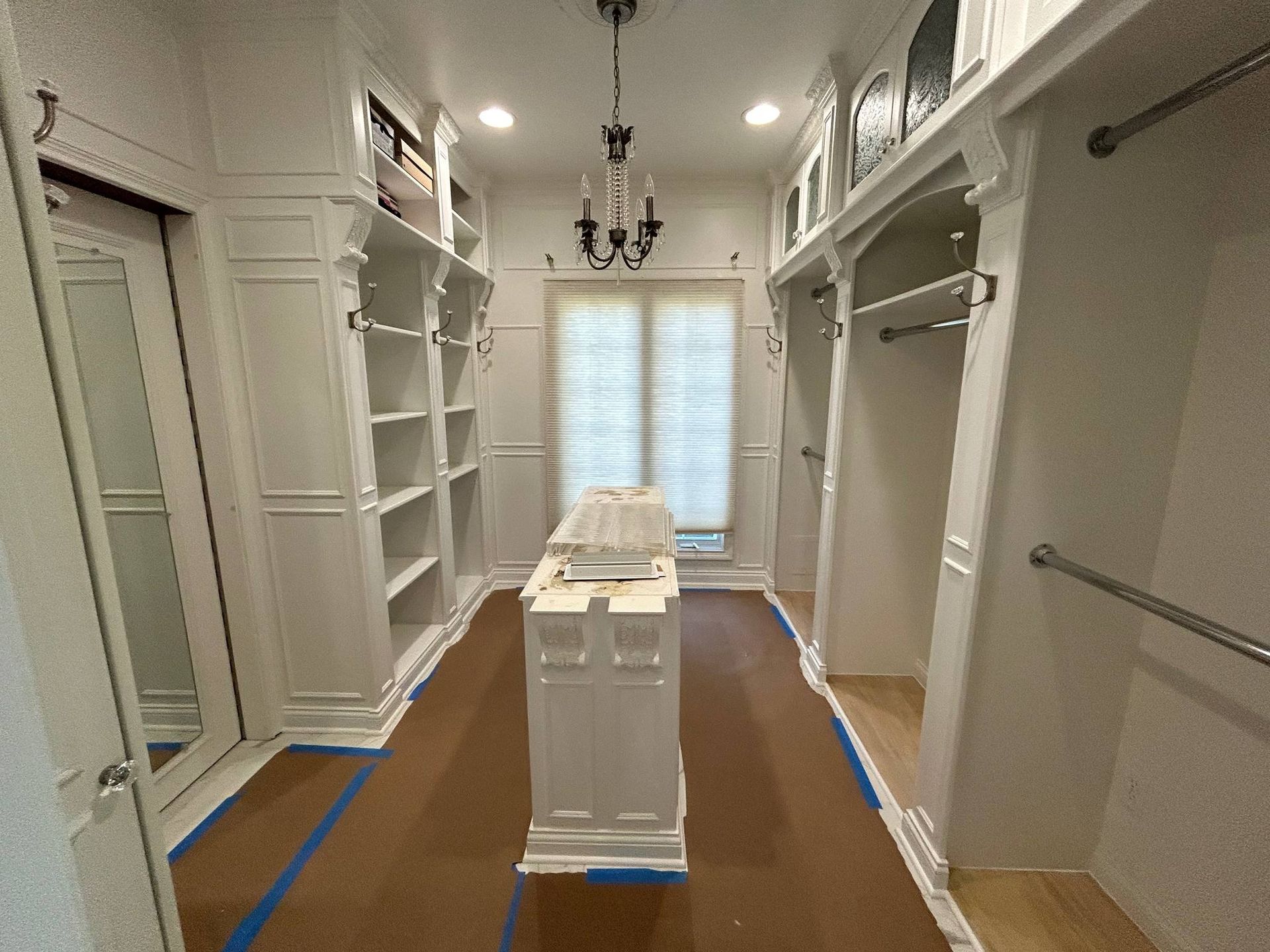 A man is painting a wall in a living room.