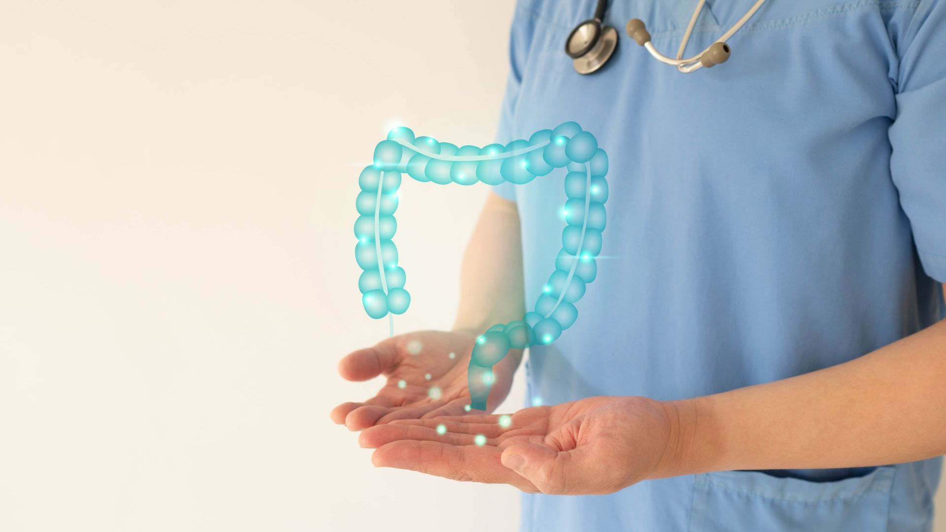 Medical professional in scrubs holding a holographic image of a human colon.