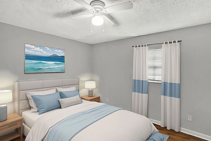 Bedroom with a bed, nightstands, window, blue and white decor, and a ceiling fan.