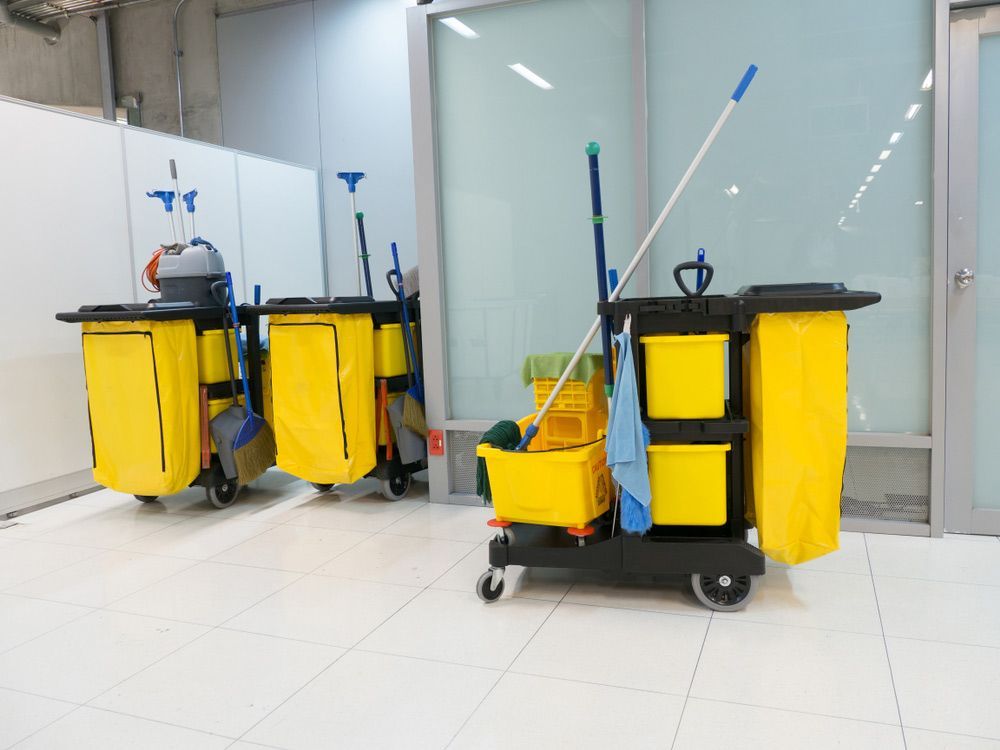 A Row of Yellow Cleaning Carts With Mops and Buckets in a Room — Shane’s Car Detailing & Office Cleaning in Barraba, NSW