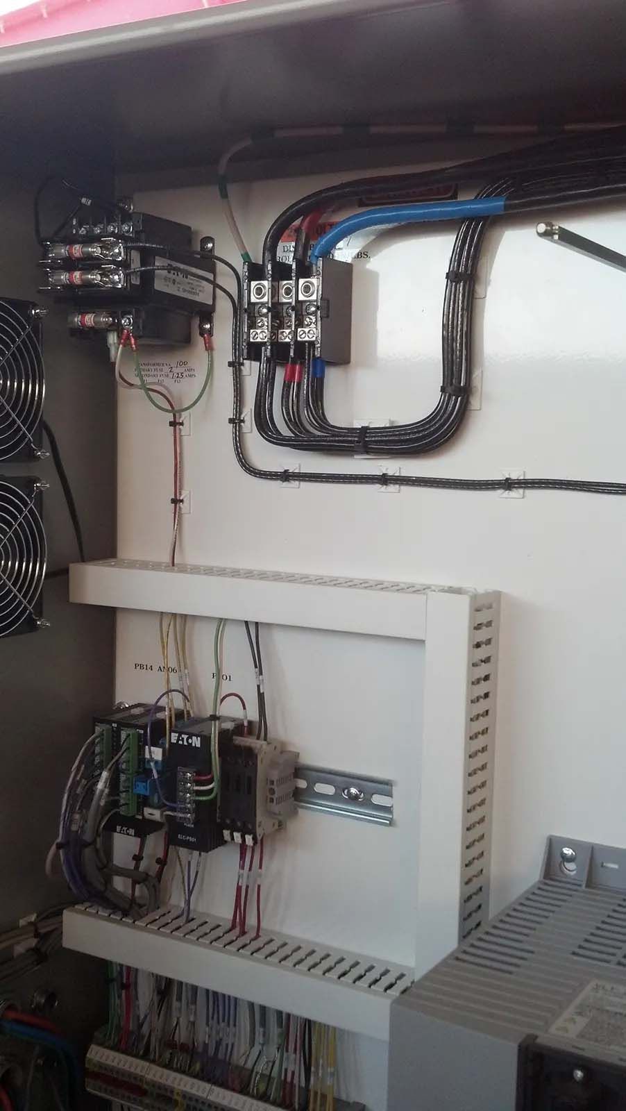 A control panel with a lot of wires coming out of it.