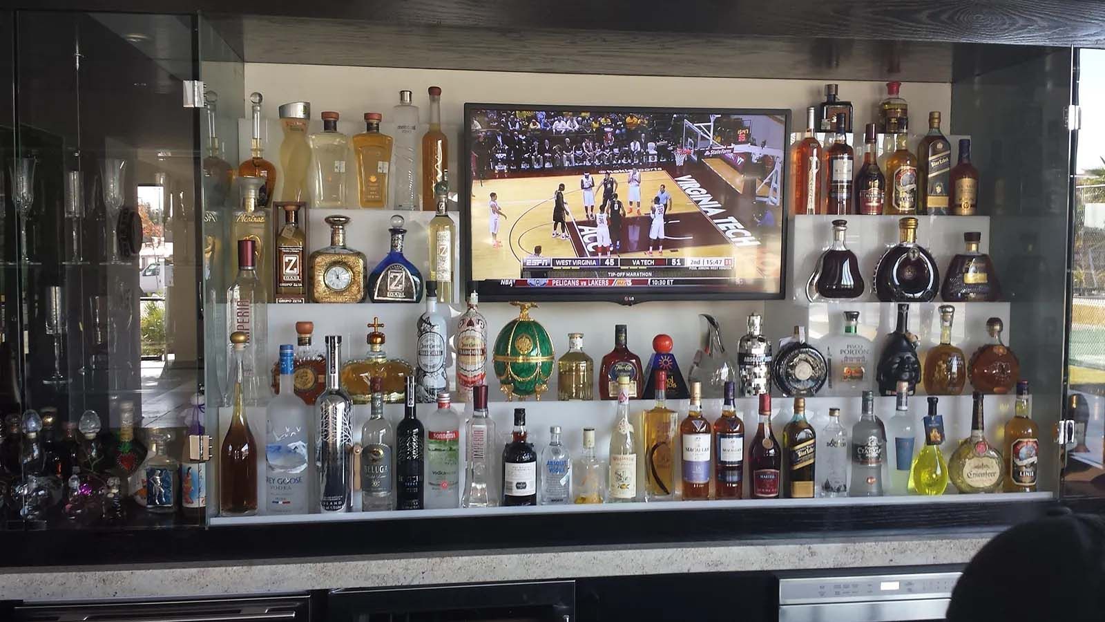 A bar filled with lots of bottles of liquor and a television