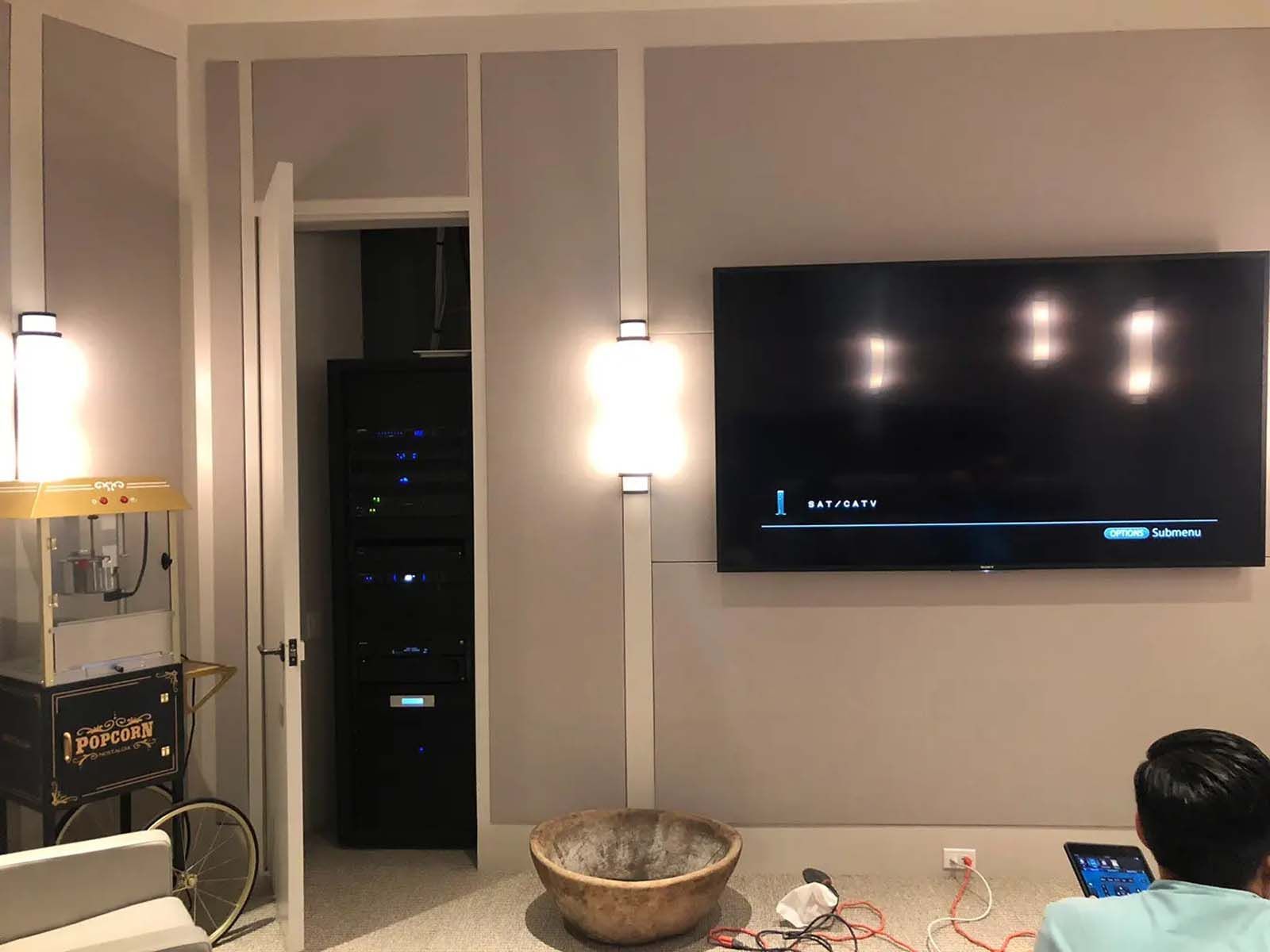 A man is sitting in front of a flat screen tv in a living room.