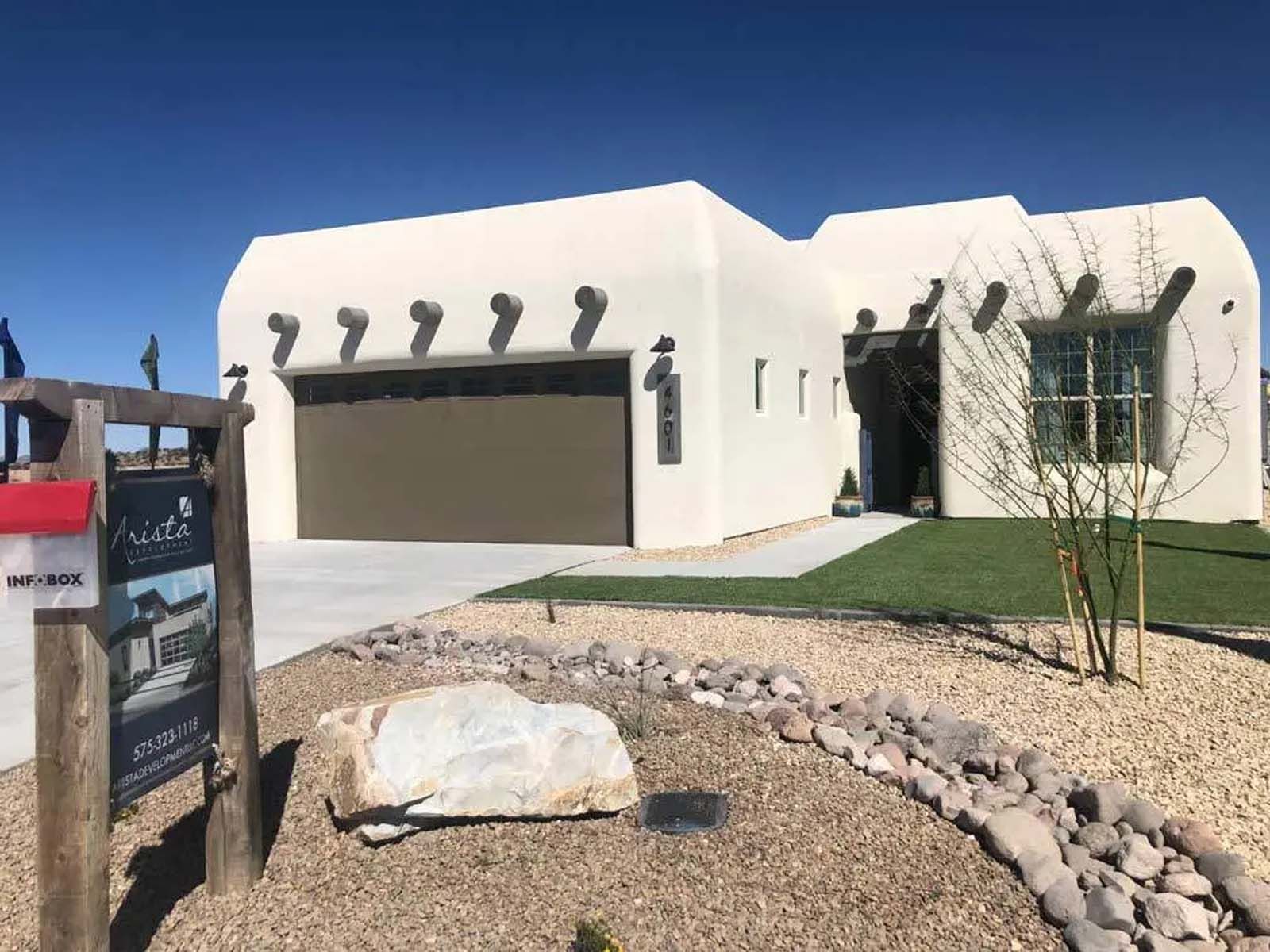 A white house with a for sale sign in front of it.