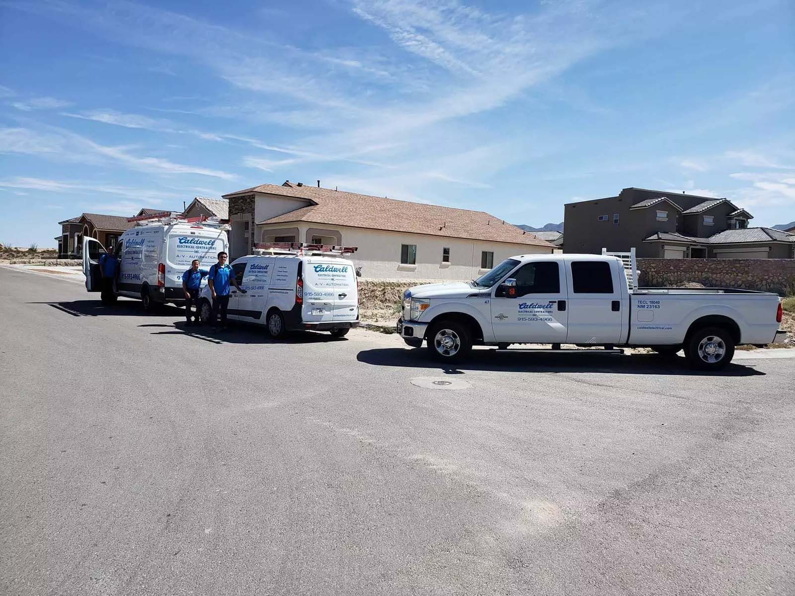 A row of white trucks parked on the side of the road