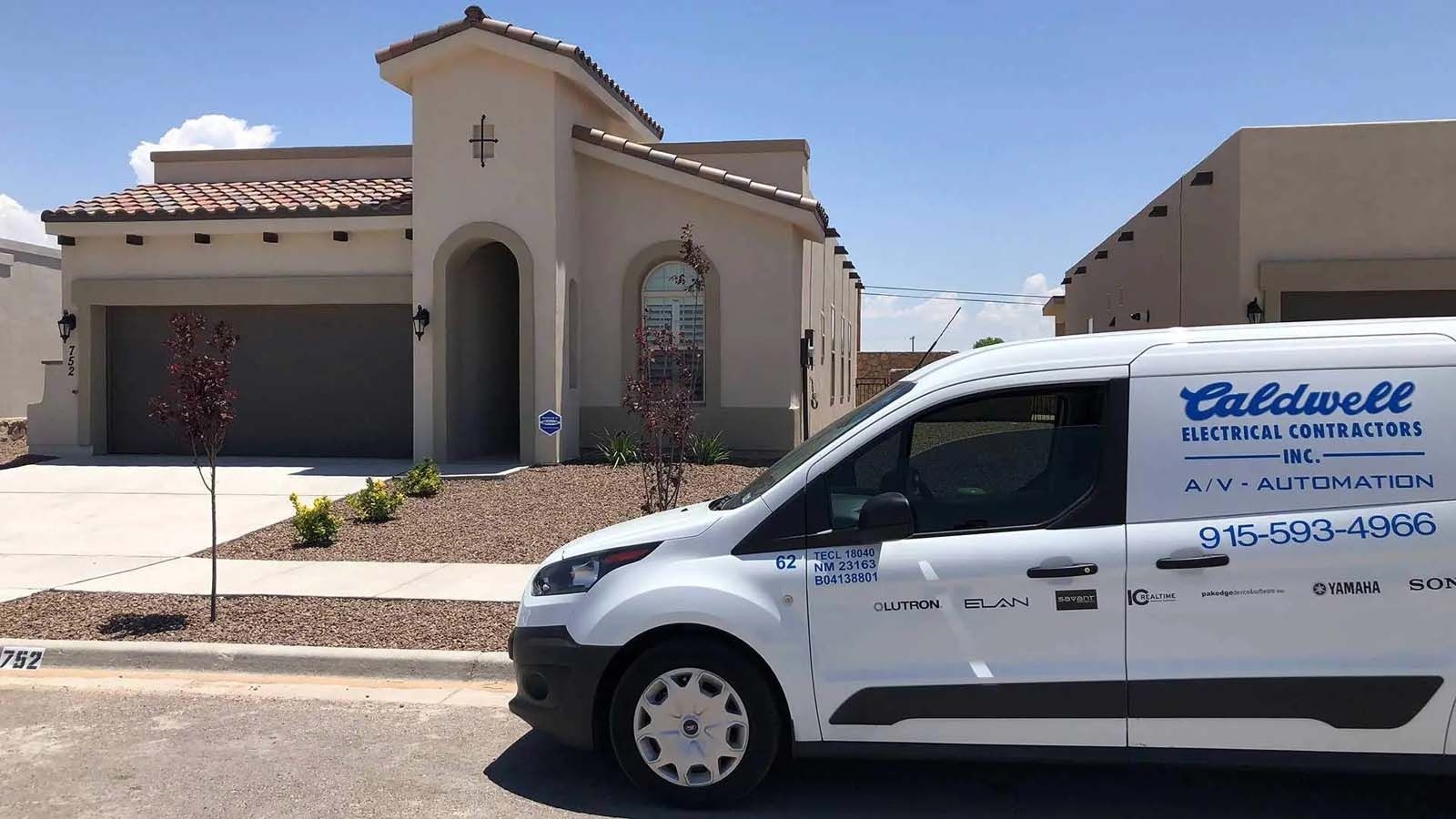 A white van is parked in front of a house.
