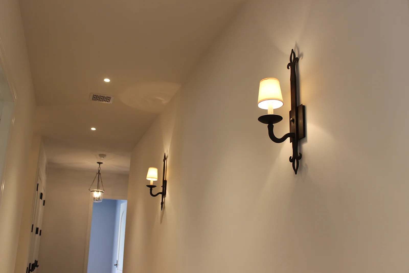 A hallway with a few lights on the wall