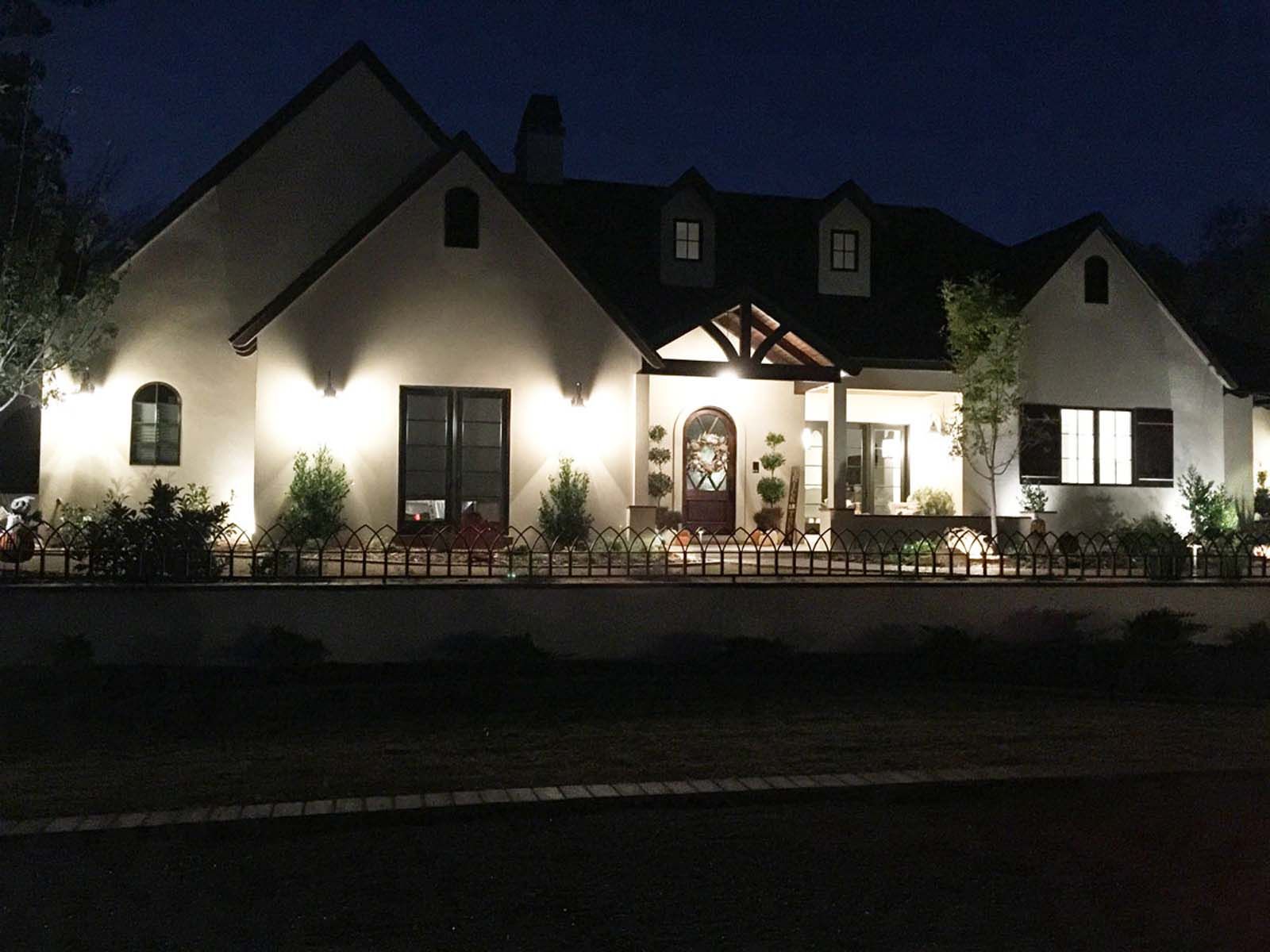 A large white house is lit up at night