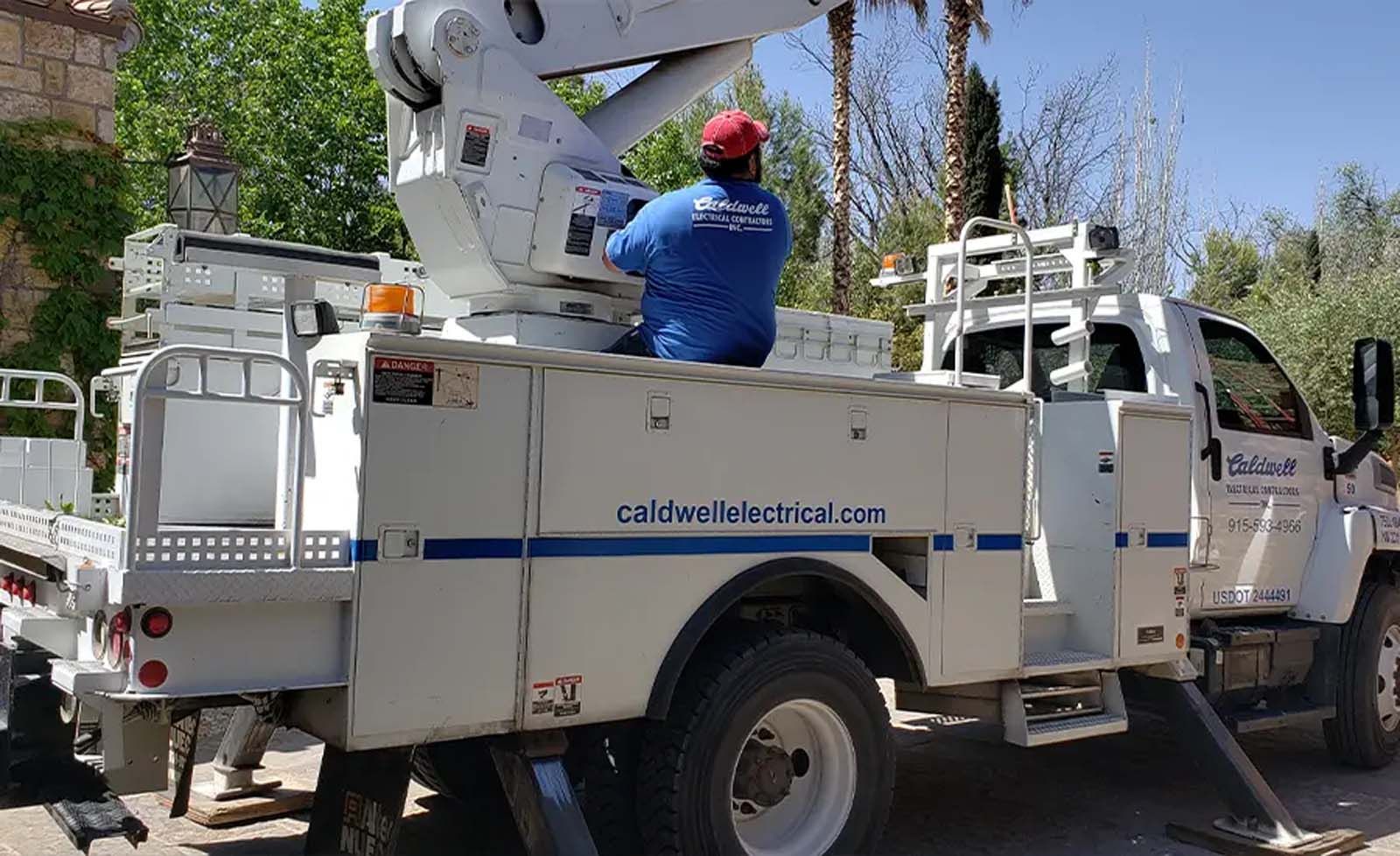 A man is sitting in the back of a utility truck.