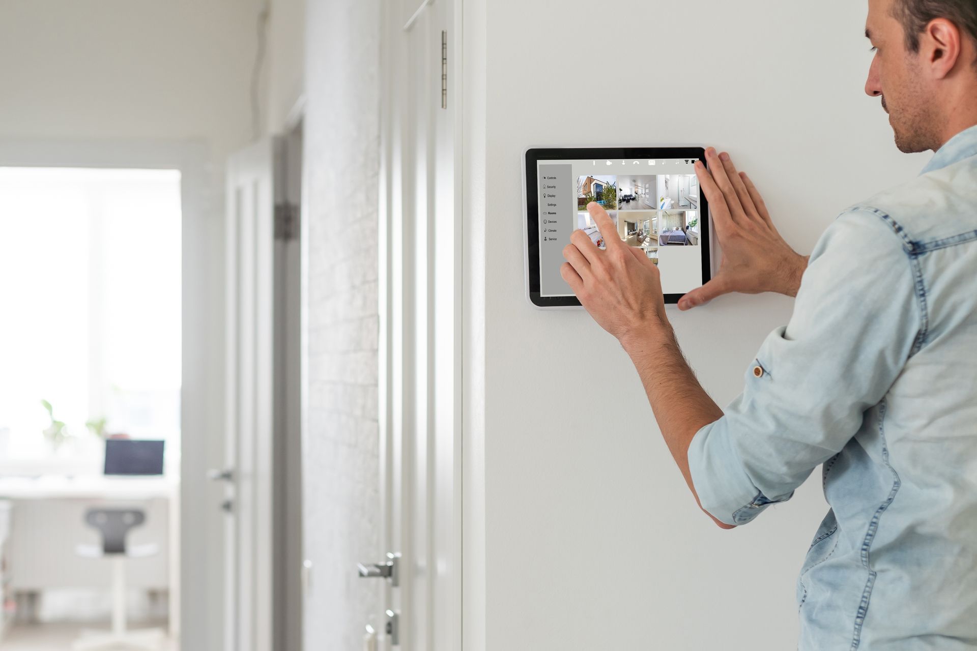 A man is using a tablet on a wall.