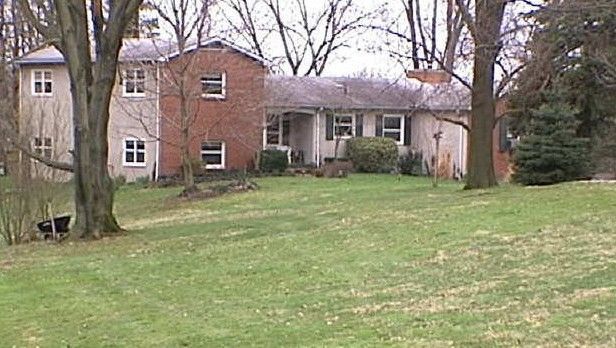 A brick house with a large lawn in front of it
