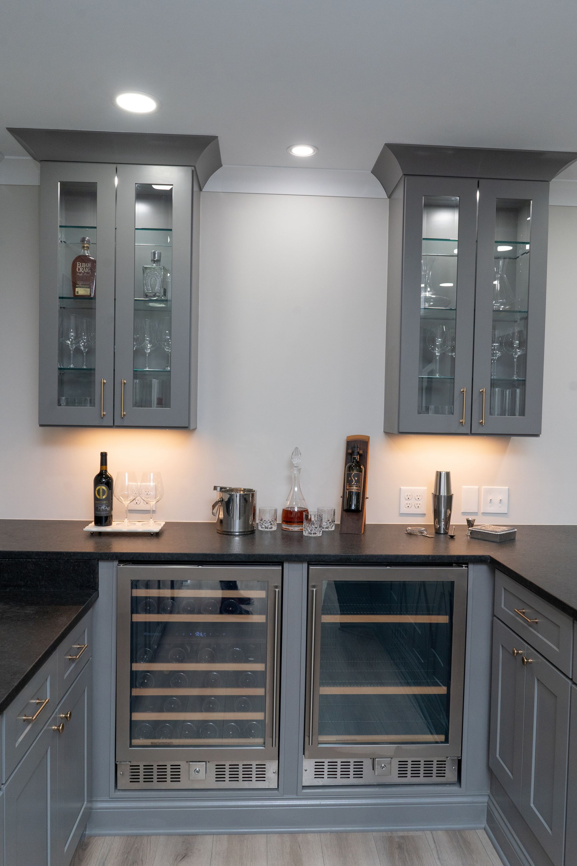 A kitchen with gray cabinets and a wine cooler